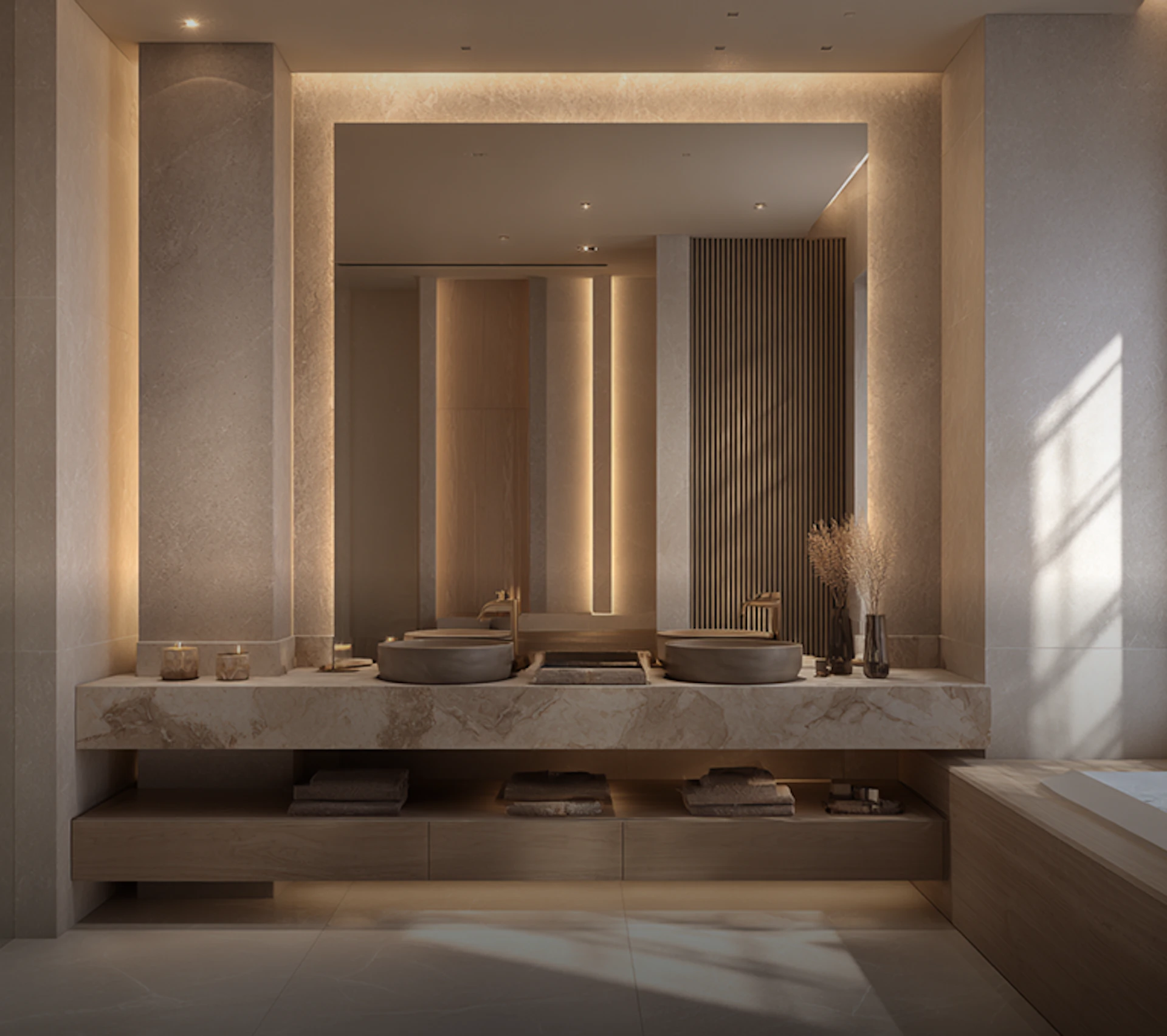 حمام حديث بتصميم أنيق، يتميز بإضاءة مخفية تجمل الحوائط الرخامية الفاتحة وحوضين دائريين على سطح رخامي، مع لمسات طبيعية من الديكور والنباتات المجففة.