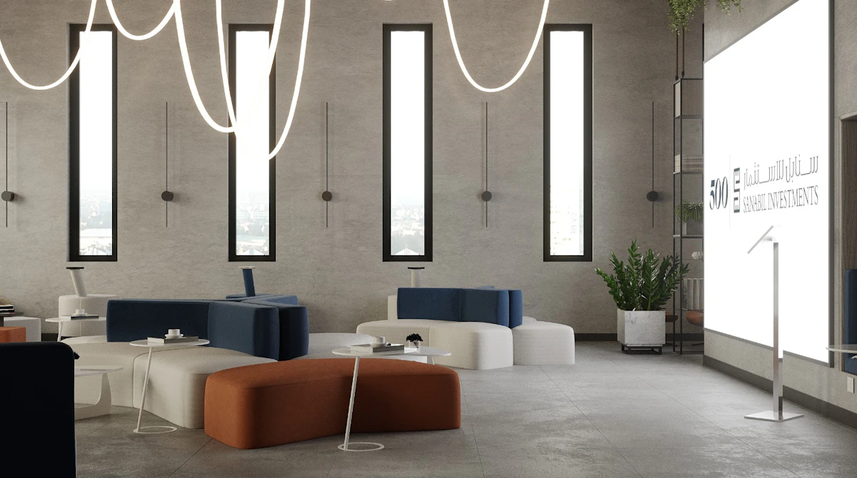 A modern, spacious office lobby with sleek furniture, featuring blue and orange cushioned seating, tall windows allowing natural light, artistic LED ceiling fixtures, and a large illuminated sign on the wall.