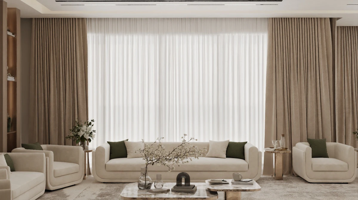 A modern living room with beige sofas and chairs arranged around a marble coffee table, featuring large windows with floor-to-ceiling beige curtains and accented by potted plants and minimalist decor.