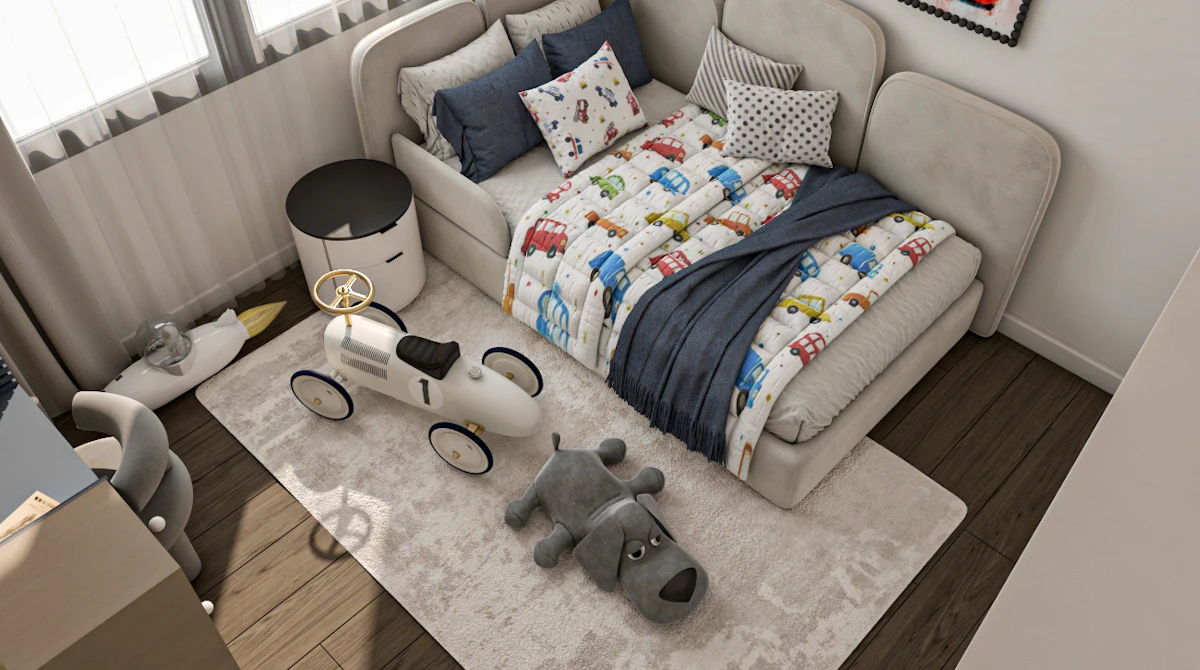 A cozy children's bedroom features a plush beige sofa bed adorned with a colorful car-themed blanket and pillows, complemented by a matching beige area rug with a toy car and a gray plush dog toy placed on it, surrounded by framed cartoon car artwork on the wall.